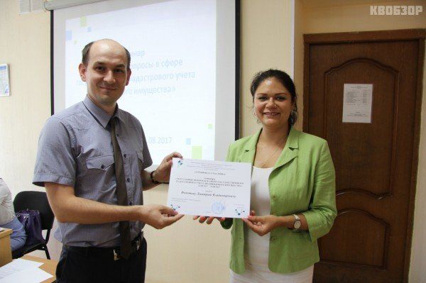 Юлия Стробыкина вручает сертификат участника семинара инженеру отдела управления собственностью Дмитрию Федотову