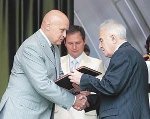 Евгений Заболотный вручает награду ветерану отрасли Аркадию Генкину